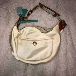 cream coach bag with blue and brown accents
